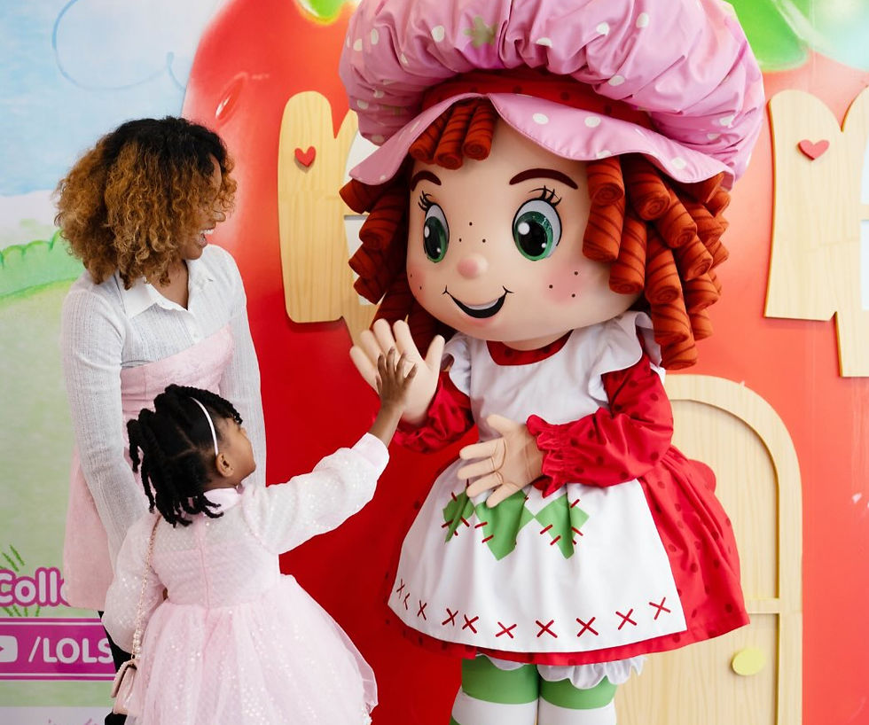 Young girl high fiving strawberry shortcake mascot